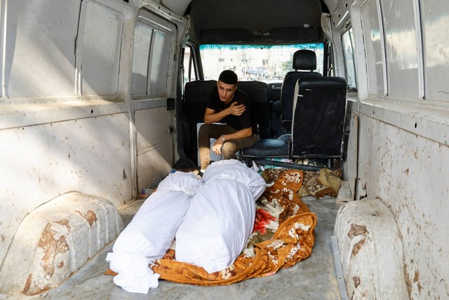 Seorang kerabat bereaksi di samping jenazah warga Palestina yang tewas dalam serangan Israel, di sebuah rumah sakit di Kota Gaza, Rabu (11/10/2023). Foto: Mohammed Salem/REUTERS