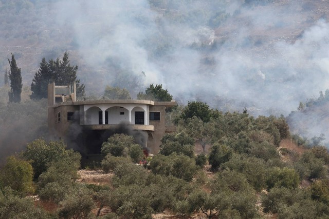 Asap mengepul setelah penembakan Israel di desa Dhayra, dekat perbatasan dengan Israel, di Lebanon selatan, Rabu (11/10/2023). Foto: Mohamed Azakir/REUTERS