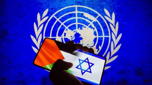 Foto ilustrasi yeng menunjukkan bendera Israel dan Palestina terpampang di layar smartphone dan dilatar belakangi bendera Persatuan Bangsa-Bangsa (PBB).
