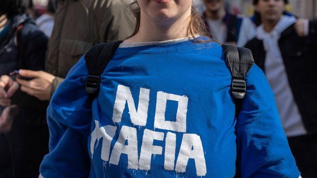 Seorang perempuan muda mengenakan kaos bertuliskan "No Mafia" di Milan, Italia.