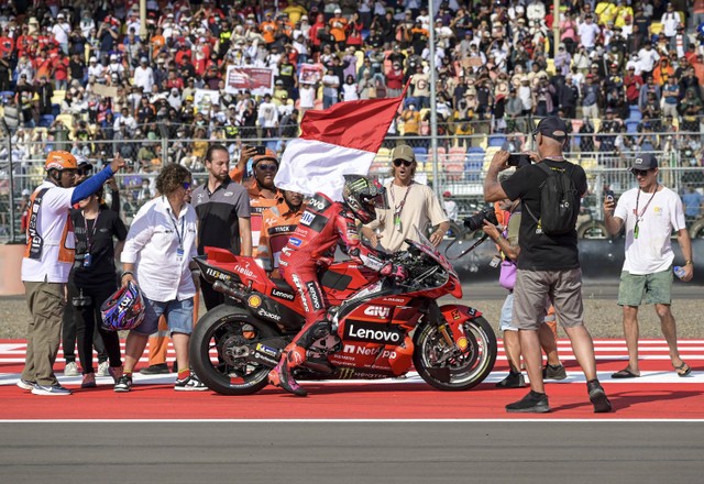 Pembalap Ducati Lenovo Team Enea Bastianini membawa bendera merah putih usai balapan MotoGP seri Pertamina Grand Prix of Indonesia 2023 di Pertamina Mandalika International Street Circuit, Lombok Tengah, NTB, Minggu (15/10/2023). Foto: ANTARA FOTO/Ahmad Subaidi