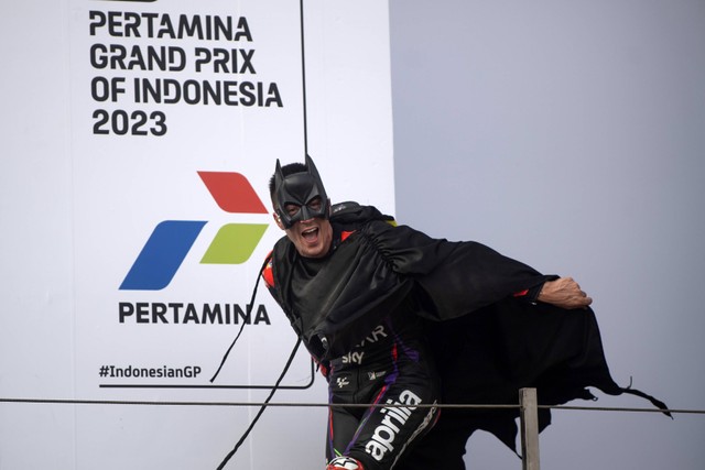 Pebalap Aprilia Racing Maverick Vinales mengenakan kostum Batman saat berada di podium seusai balapan MotoGP seri ke-15 di Pertamina Mandalika International Street Circuit, Lombok Tengah, NTB, Minggu (15/10/2023). Foto: ANTARA FOTO/Wahyu Putro A