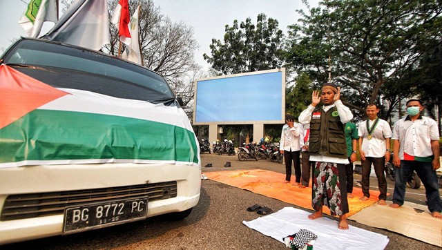 Puluhan massa aksi bela Palestina di Palembang menggelar salat gaib di kawasan simpang lima DPRD Sumsel, Senin (16/10) Foto: ary priyanto/urban id