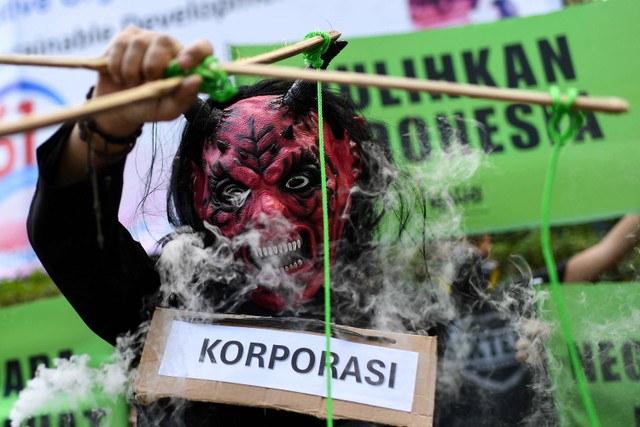 Aktivis Wahana Lingkungan Hidup (Walhi) melakukan aksi teatrikal simbolis praktik kejahatan korporasi di Kementerian Lingkungan Hidup dan Kehutanan (KLHK), Jakarta, Jumat (20/10/2023). Foto: Sigid Kurniawan/Antara Foto
