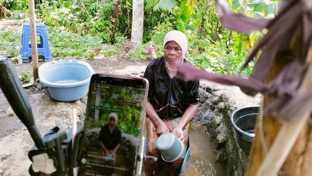 Ilustrasi seorang nenek sedang live streaming diguyur air dingin di TikTok. Foto: Istimewa