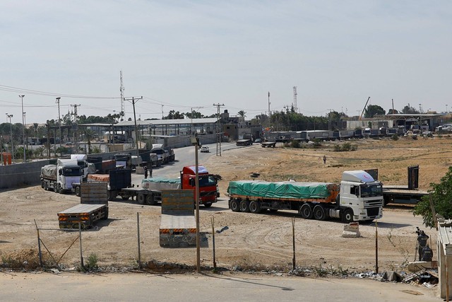 Truk yang membawa bantuan menunggu untuk keluar, di sisi perbatasan Palestina dengan Mesir, di Rafah di selatan Jalur Gaza, Sabtu (21/10/2023). Foto: Ibraheem Abu Mustafa/REUTERS