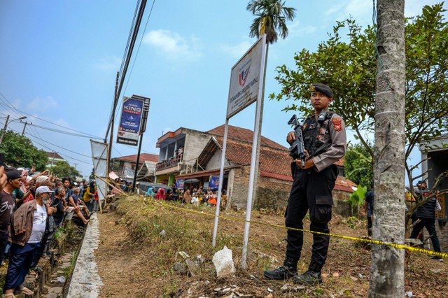 Polisi berjaga saat olah tkp pembunuhan anak dan ibu di dalam mobil di Jalan Cagak, Kabupaten Subang, Jawa Barat, Selasa (24/10/2023). Foto: Raisan Al Farisi/Antara Foto