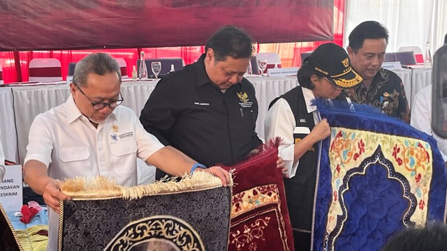 Mendan Zulkifli Hasan, Menko Perekonomian Airlangga Hartarto dan Menkeu Sri Mulyani memegang sajadah yang akan dihibahkan kepada Pemkab Bekasi di TPP Cikarang Utara pada Kamis (26/10/2023).  Foto: Widya Islamiati/kumparan