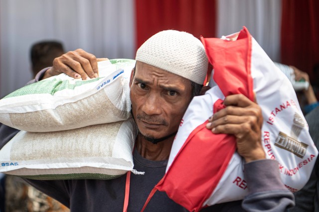 Warga membawa beras Bantuan Pangan Cadangan Beras Pemerintah dan bantuan sembako dari Presiden di Gudang Bulog Sukamaju milik Perum Bulog Divisi Regional Sumsel dan Babel di Palembang, Sumatera Selatan, Kamis (26/10/2023). Foto: Nova Wahyudi/ANTARA FOTO