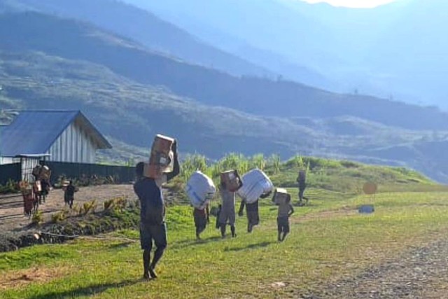 Sejumlah warga membawa bahan makanan yang diturunkan dari pesawat terbang di Distrik Amuma, Kabupaten Yahukimo, Papua Pegunungan, Kamis (26/10/2023). Foto: Humas BNPB/ANTARA FOTO