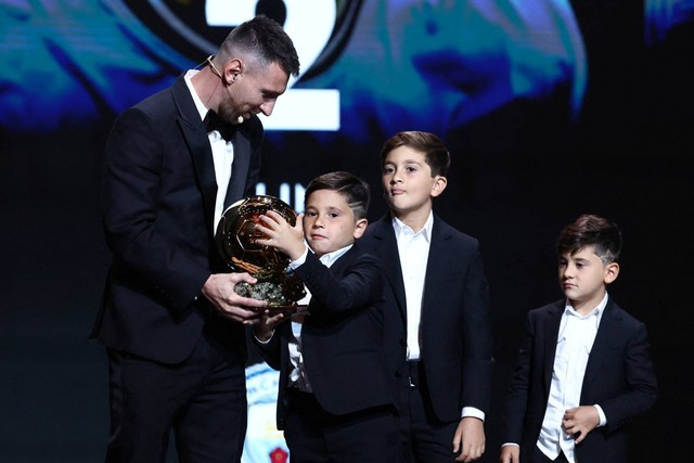 Lionel Messi memegang trofi Ballon d'Or 2023 didampingi anak-anaknya, Thiago, Mateo dan Ciro, di Teater Chatelet, Paris, Prancis, Senin (30/10/2023). Foto: Stephanie Lecocq/REUTERS 