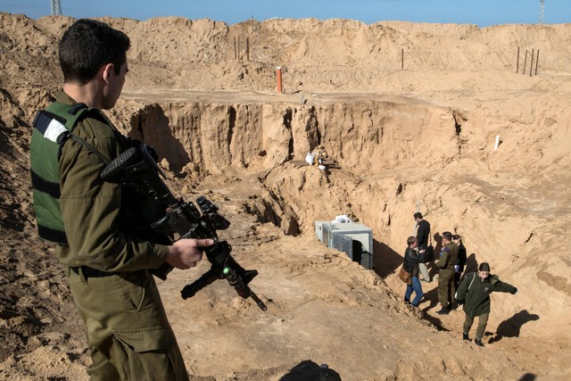 Seorang tentara Israel berjaga di dekat pintu masuk yang menurut militer Israel adalah terowongan serangan lintas batas yang digali dari Gaza ke Israel, di sisi perbatasan Jalur Gaza Israel dekat Kissufim 18 Januari 2018. Foto: Jack Guez/Pool via Reuters