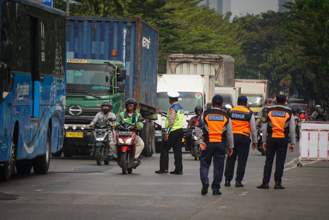 Petugas gabungan yang terdiri dari Ditlantas Polda Metro Jaya, Dinas Lingkungan Hidup DKI Jakarta dan Dinas Perhubungan DKI Jakarta menindak pengendara kendaraan bermotor di razia tilang uji emisi di kawasan Cakung, Jakarta, Rabu (1/11). Foto: Iqbal Firdaus/kumparan