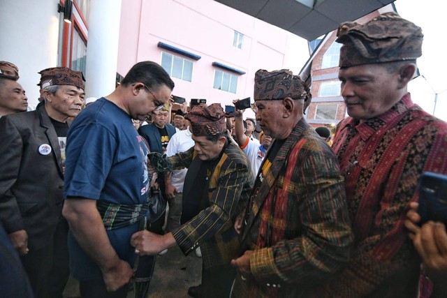 Bacapres Anies Baswedan saat diikatkan kain Hiou oleh Sekjen Partuah Maujana sekaligus Ketua Ikatan Keluarga Islam Simalungun Kota Pematangsiantar Lisman Saragih di Hotel Sapadia Siantar pada Jumat Pagi (5/11). Foto: Dok. Istimewa