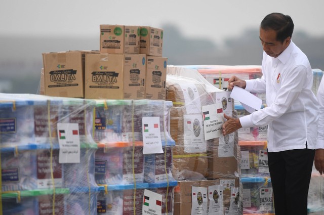 Presiden Joko Widodo menempelkan stiker pada barang bantuan untuk Palestina di Pangkalan Udara TNI AU Halim Perdana Kusuma, Jakarta, Sabtu (4/11/2023). Foto: Akbar Nugroho Gumay/Antara Foto