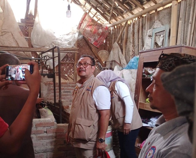 Bupati Cirebon, Imron, sambil menyerahkan bantuan rutilahu, meninjau langsung kondisi rumah warga yang masuk dalam kategori tidak layak huni di Kecamatan Mundu, Kabupaten Cirebon. Foto: Tarjoni/Ciremaitoday