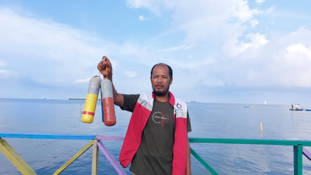 Pak Ruslan, warga Tihi-Tihi bawa Kapsurula (kapsul pelampung rumput laut) yang siap dipasang. Foto: Nabila Ulfa/kumparan