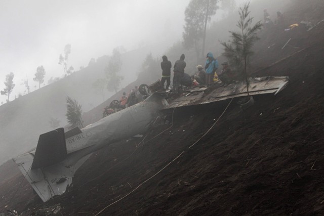 Warga berada di dekat bangkai pesawat tempur taktis EMB-314 Super Tucano TNI AU yang mengalami kecelakaan di Pasuruan, Jawa Timur, Jumat (17/11/2023). Foto: Umarul Faruq/Antara Foto