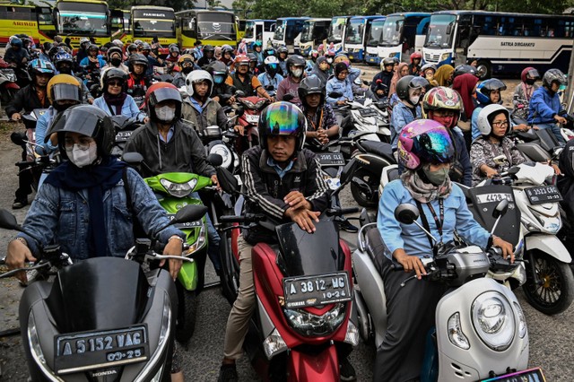 Sejumlah buruh menaiki sepeda motor saat antre pulang di salah satu pabrik di Kota Tangerang, Jumat (17/11/2023). Foto: Sulthony Hasanuddin/ANTARA FOTO 