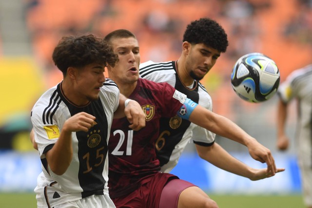 Pemain Timnas Venezuela Nicola Profeta (tengah) menggiring bola dibayangi pemain Timnas Jerman Justin Von Der Hitz (kiri) dalam penyisihan Grup F Piala Dunia U-17 2023 di Jakarta International Stadium, Jakarta, Sabtu (18/11/2023). Foto: Akbar Nugroho Gumay/ANTARA FOTO