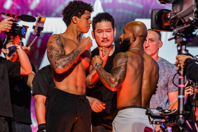 CEO dan Chairman ONE Championship, Chatri Sityodtong (tengah), menengahi sesi face-off antara Adriano Moraes dan Demetrious Johnson. Foto: ONE Championship