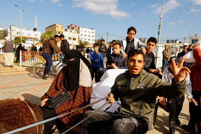 Warga Palestina menerima bantuan tepung yang didistribusikan oleh UNRWA di Rafah, di selatan Jalur Gaza, Selasa (21/11/2023). Foto: Ibraheem Abu Mustafa/REUTERS