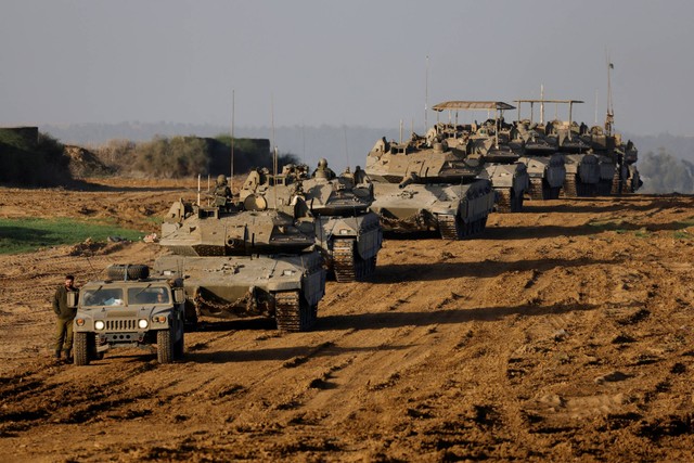 Konvoi tank militer Israel dan Pengangkut Personil Lapis Baja (APC) melewati perbatasan Israel, usai meninggalkan Gaza selama gencatan senjata, di Israel, Jumat (24/11/2023). Foto: Amir Cohen/REUTERS