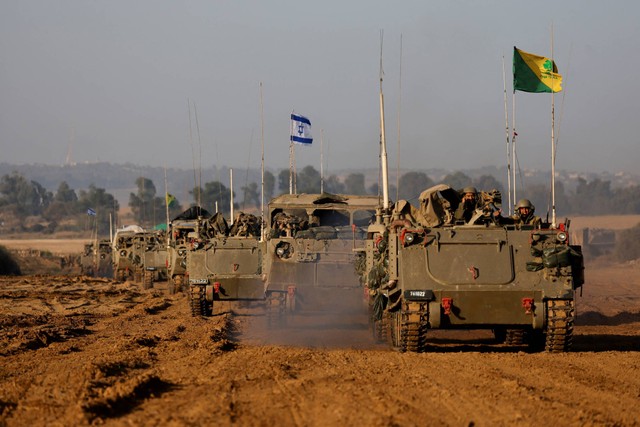 Konvoi tank militer Israel dan Pengangkut Personil Lapis Baja (APC) melewati perbatasan Israel setelah meninggalkan Gaza selama gencatan senjata, di Israel, Jumat (24/11/2023). Foto: Amir Cohen/REUTERS