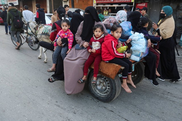 Warga Palestina menaiki kereta keledai saat mereka kembali ke rumah mereka, selama gencatan senjata sementara antara Hamas dan Israel, di Khan Younis di selatan Jalur Gaza, Jumat (24/11/2023). Foto: Ibraheem Abu Mustafa/REUTERS