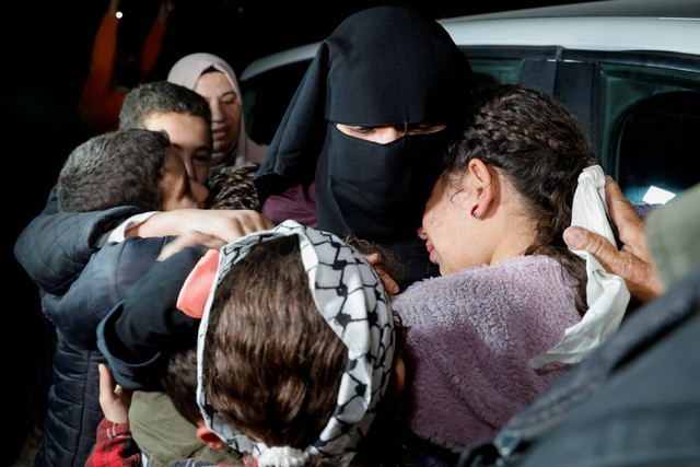 Anggota keluarga memeluk tahanan Palestina Fatima Amarneh yang telah dibebaskan, di tengah kesepakatan pertukaran sandera-tahanan antara Hamas dan Israel, dekat Jenin di Tepi Barat yang diduduki Israel, Sabtu (25/11/2023). Foto: Raneen Sawafta/REUTERS