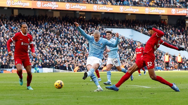 Pemain Manchester City Erling Haaland mencetak gol ke gawang Liverpool pada pertandingan Liga Inggris di Stadion Etihad, Manchester, Inggris, Sabtu (25/11/2023). Foto: Jason Cairnduff/REUTERS