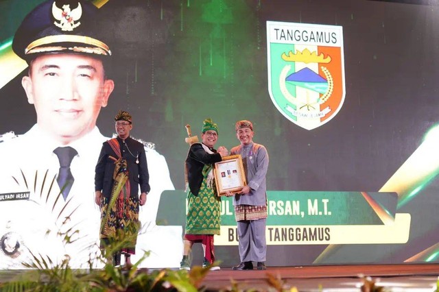 Mendes PDTT Abdul Halim Iskandar saat menyerahkan penghargaan kepada Pj Bupati Tanggamus Mulyadi Irsan. | Foto : Dok. Pemkab Tanggamus