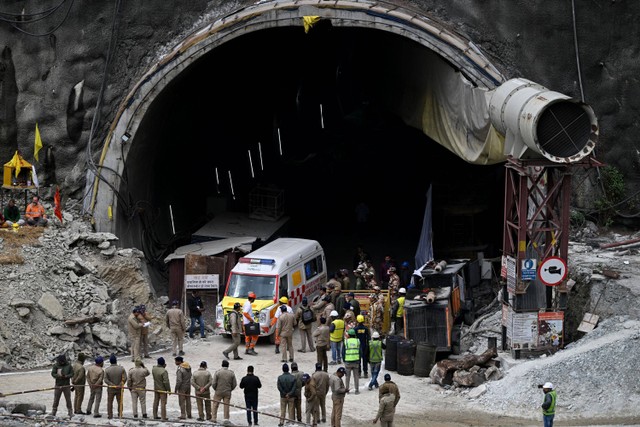 Ambulans dan petugas penyelamat berkumpul di dekat reruntuhan terowongan Silkyara yang sedang dibangun di distrik Uttarkashi, negara bagian Uttarakhand, India, Selasa (28/11/2023). Foto: Sajjad HUSSAIN / AFP