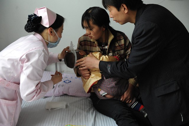 Seorang perawat Tiongkok memeriksa kesehata balita di rumah sakit di Hefei, provinsi Anhui, Tiongkok. Foto: AFP