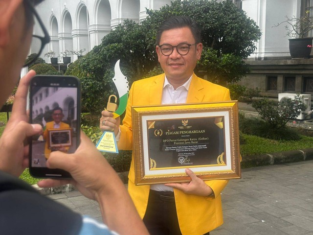 Ketua DPD Partai Golkar Provinsi Jawa Barat, Tubagus Ace Hasan Syadzily, menunjukkan piagam penghargaan Anugrah Keterbukaan Informasi Badan Publik kategori Partai Politik dari Komisi Informasi Jawa Barat.