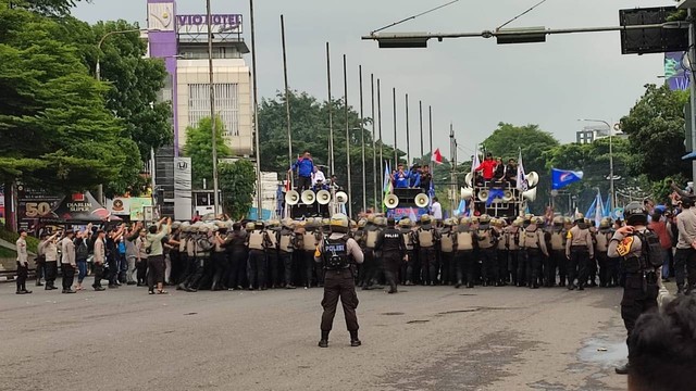 Polisi adang long march buruh di simpang Jalan Dr Djunjunan-Jalan Surya Sumantri saat menuju ke Gate Tol Pasteur, Bandung, Kamis (30/11/2023). Foto: Rachmadi Rasyad/kumparan