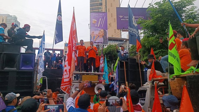 Massa buruh Jatim yang menggelar aksi berhenti dan melakukan orasi di Jalan Basuki Rahmat, Surabaya, Kamis (30/11/2023). Foto: Farusma Okta Verdian/kumparan