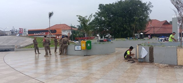 Satpol PP dan kuli bangunan terlihat di Alun-Alun Karawang pada Jumat (1/12/2023). Dok: kumparan