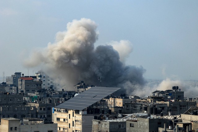 Asap mengepul di atas gedung-gedung selama serangan Israel di Rafah di Jalur Gaza selatan, Jumat (1/12/2023). Foto: Said Khatib/AFP