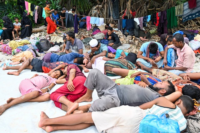 Pengungsi Rohingya yang baru tiba beristirahat di sebuah pantai di pulau Sabang, provinsi Aceh, pada 2 Desember 2023. Foto: CHAIDEER MAHYUDDIN / AFP