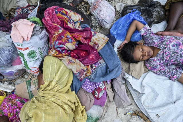 Pengungsi Rohingya yang baru tiba beristirahat di sebuah pantai di pulau Sabang, provinsi Aceh, pada 2 Desember 2023. Foto: CHAIDEER MAHYUDDIN / AFP