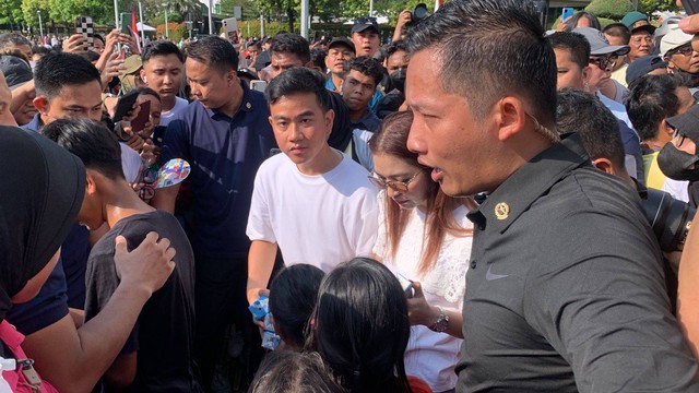 Cawapres nomor urut 2 Gibran Rakabuming Raka membagi-bagikan susu kepada anak-anak di kawasan CFD Bundaran HI, Jakarta, Minggu (3/12/2023). Foto: Luthfi Humam/kumparan