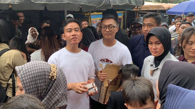 Cawapres nomor urut 2 Gibran Rakabuming Raka dan istrinya Selvi Ananda blusukan membagi-bagikan susu kepada masyarakat di Pasar Rawasari, Cempaka Putih, Jakarta pada Minggu (3/12/2023). Foto: Luthfi Humam/kumparan