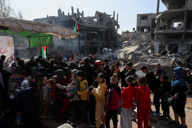 Warga Palestina berkumpul untuk mendapatkan bagian dari makanan amal yang diberikan oleh para sukarelawan di Rafah, Jalur Gaza selatan, Sabtu (2/12/20223). Foto: Ibraheem Abu Mustafa/REUTERS