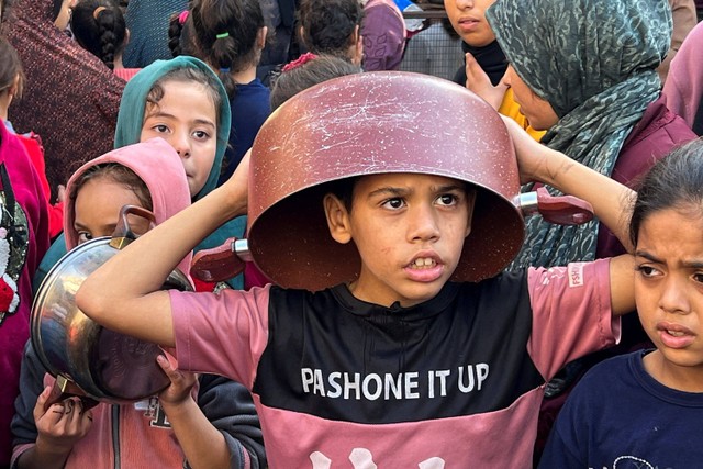 Seorang anak antre untuk mendapatkan bagian dari makanan amal yang diberikan oleh para sukarelawan di Rafah, Jalur Gaza selatan, Sabtu (2/12/20223). Foto: Ibraheem Abu Mustafa/REUTERS