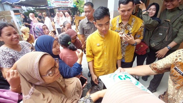 Gibran bagikan susu dan beras pada warga di acara penyerahan hadiah lomba mewarnai Piala Wali Kota Solo di SDN Gurawan, Kecamatan Semanggi, Pasar Kliwon Solo, Kamis (7/12/2023). Foto: kumparan