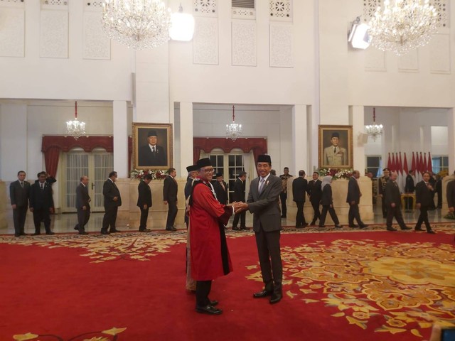 Presiden Jokowi dan Wapres Ma'ruf Amin memberikan selamat kepada Hakim MK Ridwan Mansyur. Foto: Nadia Riso/kumparan