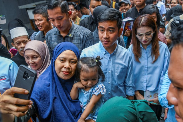 Calon wakil presiden nomor urut 2 Gibran Rakabuming Raka menyapa warga saat melakukan blusukan di Kawasan Cempaka Putih, Jakarta, Sabtu (9/12/2023). Foto: Galih Pradipta/ANTARA FOTO