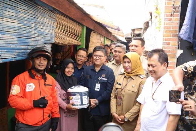 Dirjen Ketenagalistrikan, Jisman Hutajulu (Tengah) secara simbolis menyerahkan rice cooker kepada warga di Pulo Gebang, Jakarta Timur. Foto: Dok. Kementerian ESDM