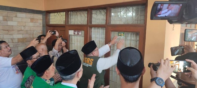 Kanwil Kementerian Agama Jabar memasang stiker Gerakan Keluarga Maslahat Nahdlatul Ulama (GKMNU) di kediaman seorang warga di Lembang, Kabupaten Bandung Barat, pada Jumat (15/12). Foto: Istimewa